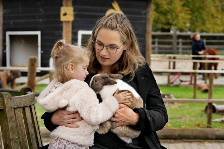 Foto Carla en haar dochtertje. Ze aaien een konijn. Moeder Carla ontving een donorhart.