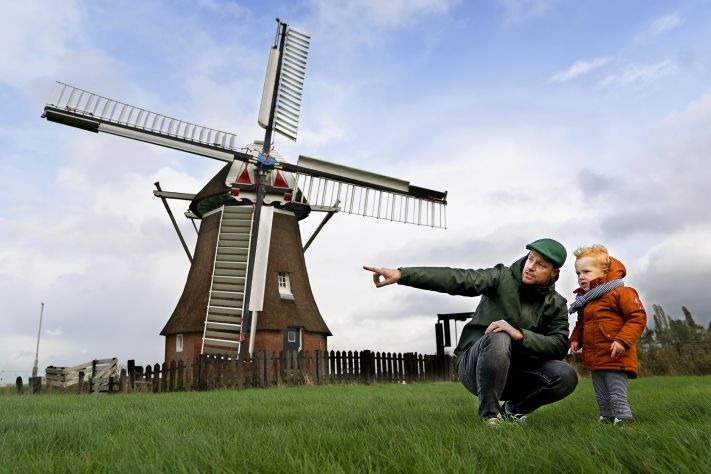 Foto Peuter Lenn en zijn vader Robert Oostmeijer, staan in een weiland bij een molen.