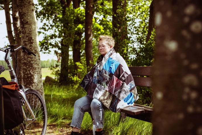 Jitske op een bankje, met haar troostdeken gemaakt van Teun's kleding