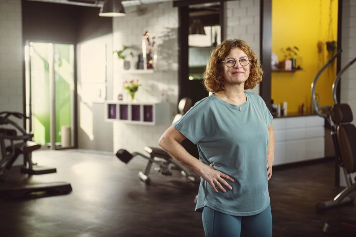 Gerda staat in de sportschool met haar handen in haar zij